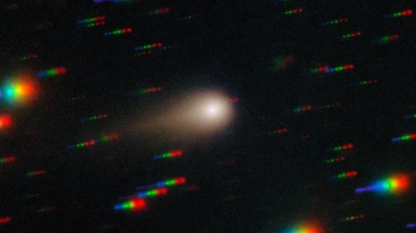 Значні частини Інтернету недоступні для тисяч користувачів, зокрема для X, раніше відомого як Twitter, через проблеми з Cloudflare. На цьому зображенні, отриманому за допомогою багатооб'єктного спектрографа Gemini (GMOS) на південному зоряному супутнику Gemini у Серро-Пачан у Чилі, що є частиною Міжнародної обсерваторії Gemini, частково фінансованої Національним науковим фондом США (NSF) та керованої NSF NOIRLab, комета 3I/ATLAS пронизує щільне зоряне поле. Це зображення складається з експозицій, зроблених через чотири фільтри - червоний, зелений, синій та ультрафіолетовий. Під час зйомки комета залишається нерухомою в центрі поля зору телескопа. Однак положення зірок фону змінюється відносно комети, через що на кінцевому зображенні вони виглядають як різнокольорові смуги. Дивіться версію зображення, де зірки