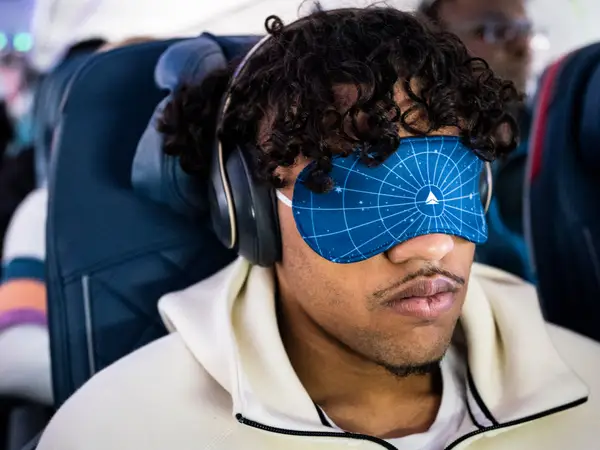 Пасажир у своїй ексклюзивній масці для очей під час рейсу Delta Airlines з Далласа до Детройта в міжнародному аеропорту Даллас-Форт-Верт.