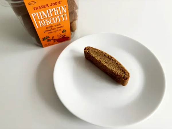 Коробка гарбузових біскоті від Trader Joe's поруч із білою тарілкою з печивом.
