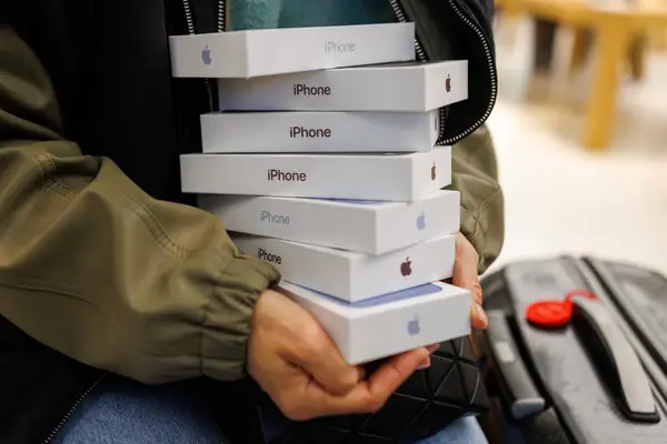A customer in London, England, holds seven iPhone 18 Pro boxes.