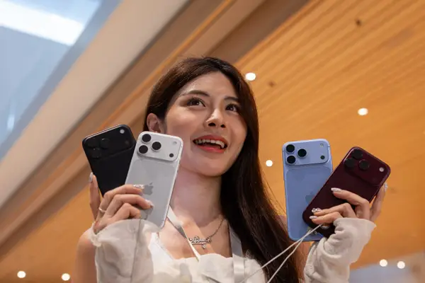 A shopper holds four iPhone 18s in Kuala Lumpur, Malaysia.