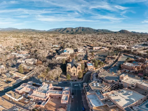 Aerial view of downtown Santa Fe with the Cathedral Basilica of St. Francis of Assisi and surrounding mountains.