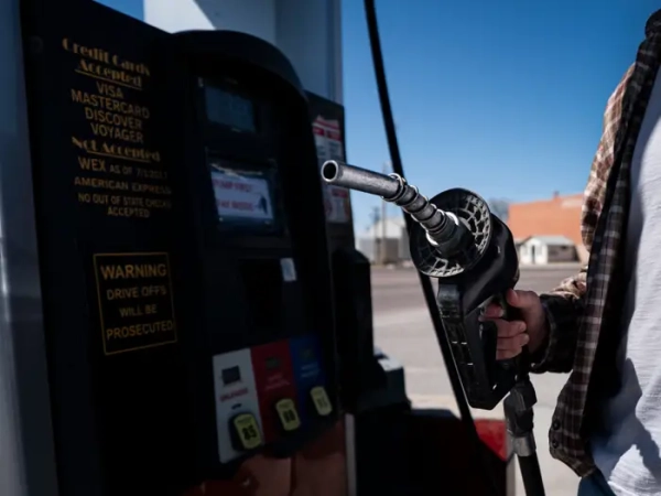 A man holds a gas pump.